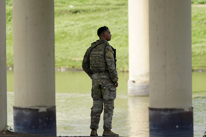A member of the Texas National Guard looks across the Rio Grande to Mexico from the U.S. at Eagle Pass, Texas, on Aug. 26.