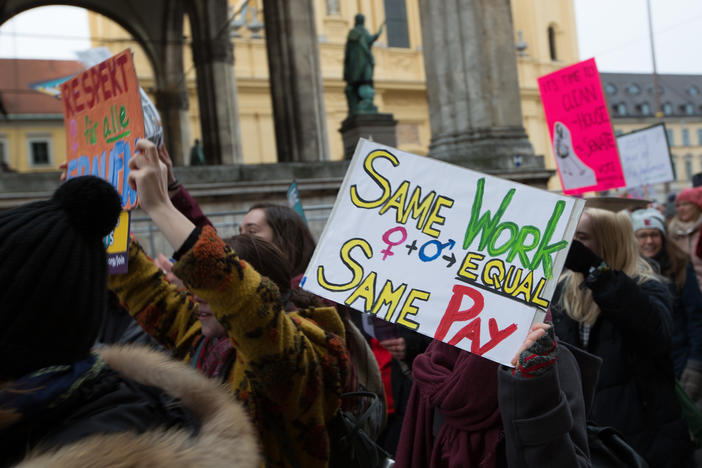 Woman hold a banner for equal pay during a 2018 march in Munich, Germany.