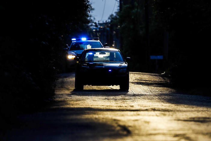 Memphis police officers search an area where a body had been found in South Memphis, Tenn., near Victor Street and East Person Ave., Monday, Sept. 5, 2022.