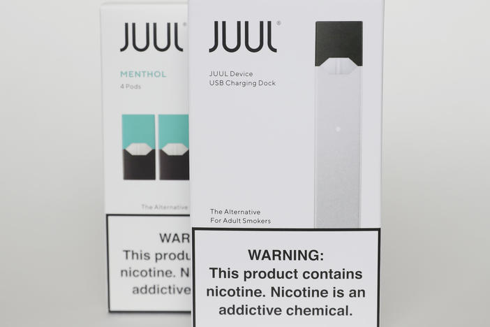 Packaging for an electronic cigarette and menthol pods from Juul Labs is displayed on Feb. 25, 2020, in Pembroke Pines, Fla. In a deal announced Tuesday, Juul will pay nearly $440 million to settle a two-year investigation by 33 states into the marketing of its high-nicotine vaping products.