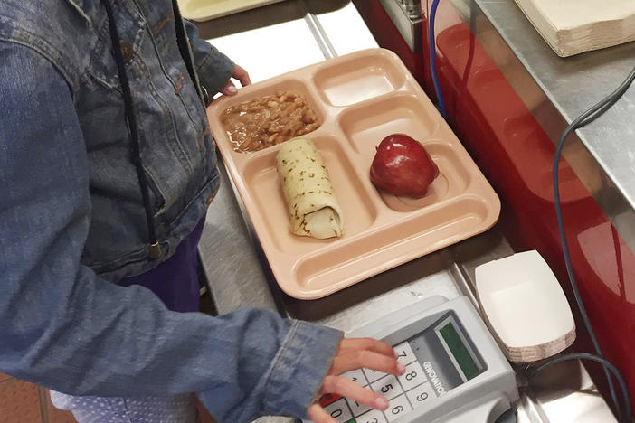 A third-grader punches in her student identification to pay for a meal at Gonzales Community School in Santa Fe, N.M. During the pandemic, schools were able to offer free school meals to all children regardless of need. Now advocates want to make that policy permanent.