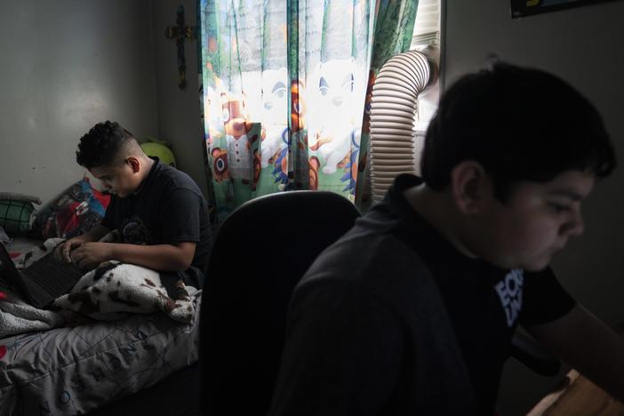Eloyd Castro, 11, izquierda, juega videojuegos con su hermano Emmanuel Castro, 12, derecha, en su casa en Uvalde, Texas.