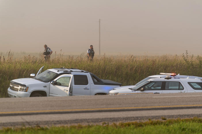 Police and investigators gather at the scene where a stabbing suspect was arrested in Rosthern, Saskatchewan, on Wednesday.