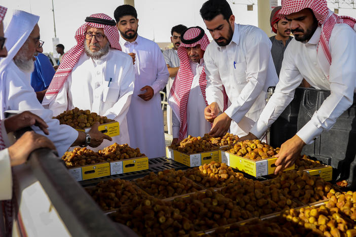 Boxes of dates are auctioned off by the tens of kilos at the Buraydah Date Festival in Buraydah, Saudi Arabia, on Aug. 3, 2022.