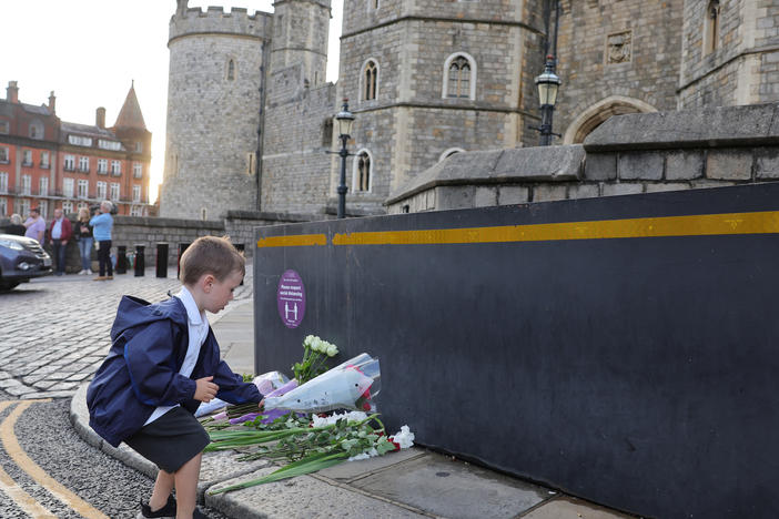 Queen Elizabeth II's death sets a succession apparatus in motion that has been dormant for decades. Here, a youngster leaves flowers outside Windsor Castle on Thursday.