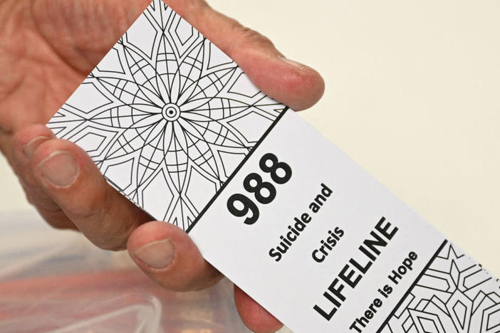A bookmark advertising the 988 suicide and crisis lifeline emergency telephone number displayed by a volunteer with the Natrona County Suicide Prevention Task Force, in Casper, Wyoming on August 14, 2022.