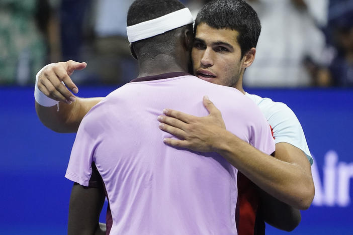 Carlos Alcaraz (right) hugs Frances Tiafoe after winning their semifinal match of the U.S. Open tennis championships on Friday in New York.