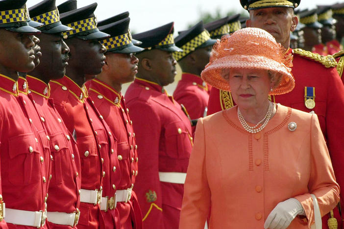 Troops parade for Queen Elizabeth II as she arrives in Kingston, Jamaica, in 2002.