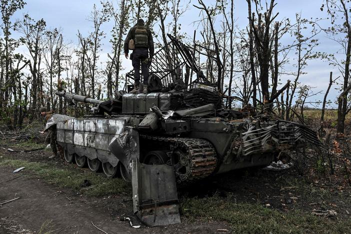 A Ukrainian soldier stands atop an abandoned Russian tank near a village on the outskirts of Izium, in the Kharkiv region, eastern Ukraine. Ukraine said its swift offensive took significant ground back from Russia.