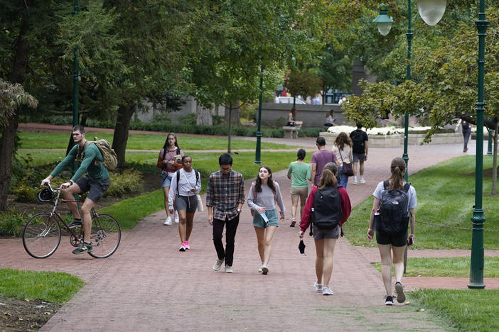 Students walk to and from classes on the Indiana University campus, Thursday, Oct. 14, 2021, in Bloomington, Ind. Indiana will tax student debt relief as income, reflecting similar policies in other U.S. states following the Biden administration's announcement of a forgiveness plan in August 2022.