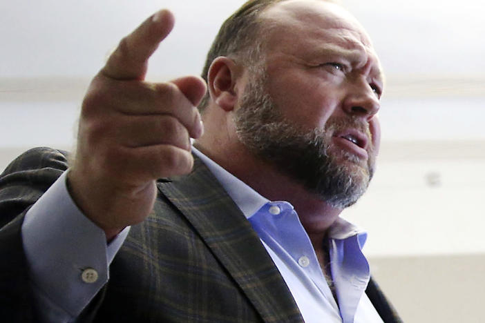 Alex Jones talks to reporters during a break in his trial in Austin, Texas, on July 26.