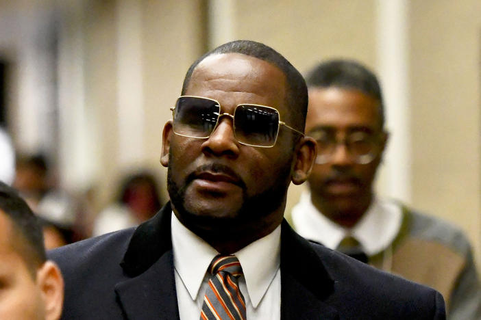 Musician R. Kelly (center) was found guilty Wednesday on three counts of child pornography but was acquitted of a conspiracy to obstruct justice charge accusing him fixing his state child pornography trial in 2008.