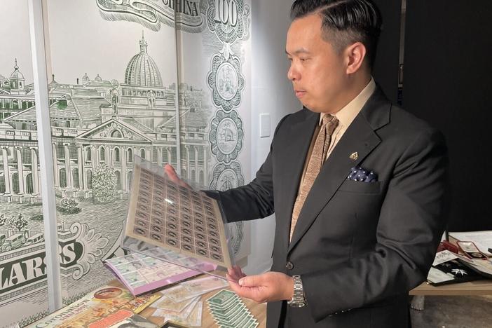 Museum owner Bryan Ong looks at old postage stamps from British Hong Kong at the private museum The Museum Victoria City in Hong Kong, on Sept. 10, 2022.