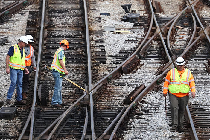 Workers service the tracks at the Metra/BNSF railroad yard in Chicago