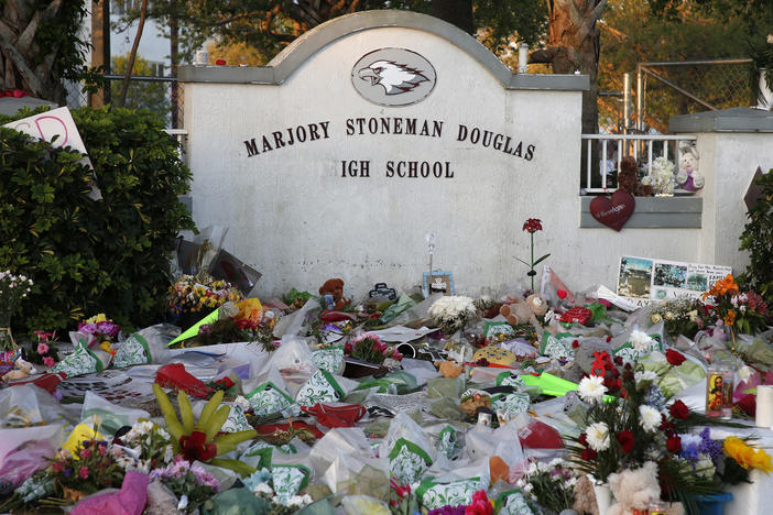 Flowers, candles and mementos sit outside one of the makeshift memorials at Marjory Stoneman Douglas High School in Parkland, Florida on February 27, 2018.