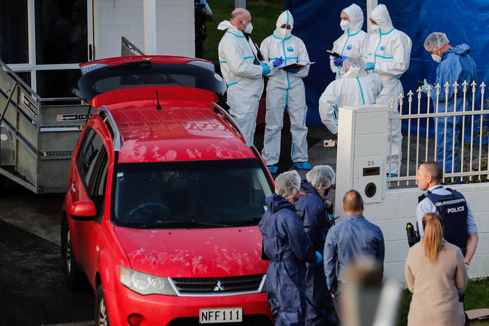 New Zealand police investigators work at a scene in Auckland on Aug. 11, 2022, after bodies were discovered in suitcases.