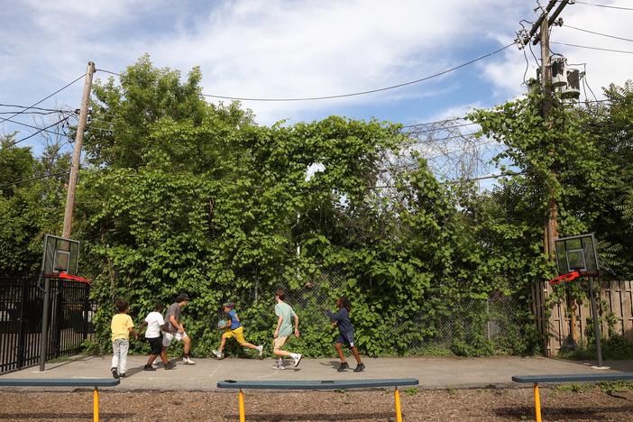 Volunteers from McQuaid Jesuit High School play basketball with the children of Cameron Community Ministries' after-school program.