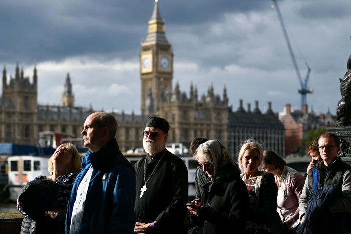 Members of the public stand in the queue as they wait in line to pay their respects to the late Queen Elizabeth II in London on Thursday.