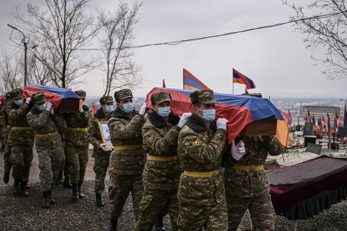 Soldiers carry coffins during funerals at a military cemetery in Yerevan, Armenia's capital, on March 2, 2021, for fighters killed during the war in Nagorno-Karabakh.