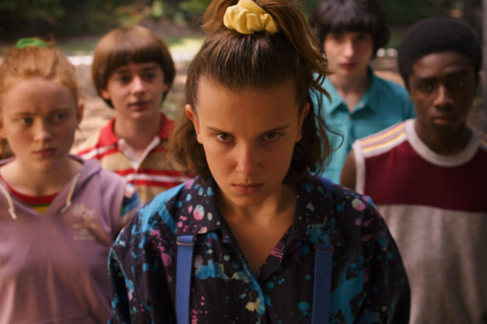 In the 2019 season of <em>Stranger Things</em>, Eleven (portrayed by Millie Bobby Brown<em>) </em>pulls a half-pony with a yellow scrunchie.