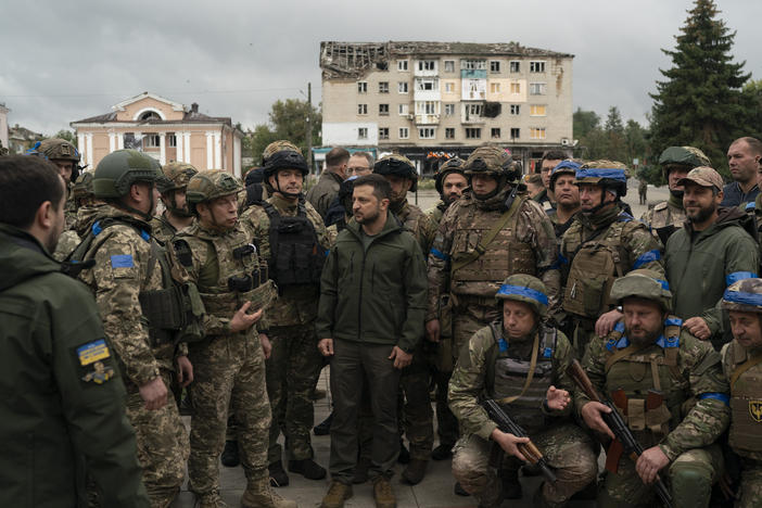 Ukrainian President Volodymyr Zelenskyy stands with soldiers after attending a national flag-raising ceremony in Izium, Ukraine, on Wednesday. Zelenskyy thanked soldiers for their efforts in retaking the area, as the Ukrainian flag was raised in front of the burned-out city hall building.