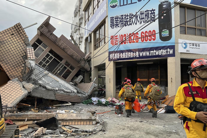 This photo provided by Hualien County fire department show firefighters in the search for trapped victims in a collapsed residential building following earthquake in Yuli township in Hualien County, eastern Taiwan, Sunday, Sept. 18, 2022.