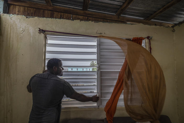 Nelson Cirino secures the windows of his home as the winds of Hurricane Fiona blow in Loiza, Puerto Rico, on Sunday.