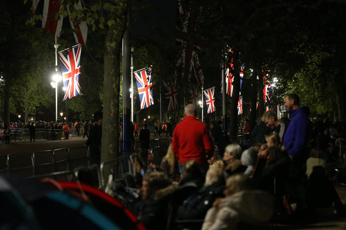 Groups of people camp outside Buckingham Palace in London.