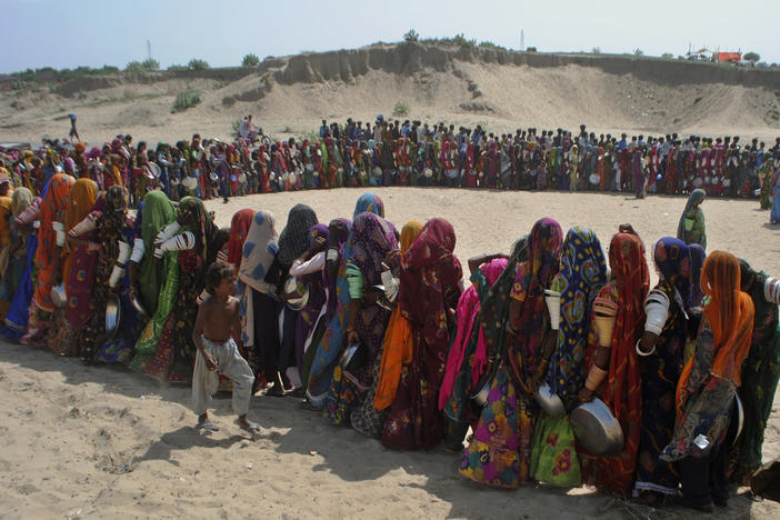 People wait in line for food in Sindh province, Pakistan, on Sept. 19, 2022. The province was one of the hardest hit by recent deadly floods. A new analysis confirms that climate change likely helped cause the disaster.