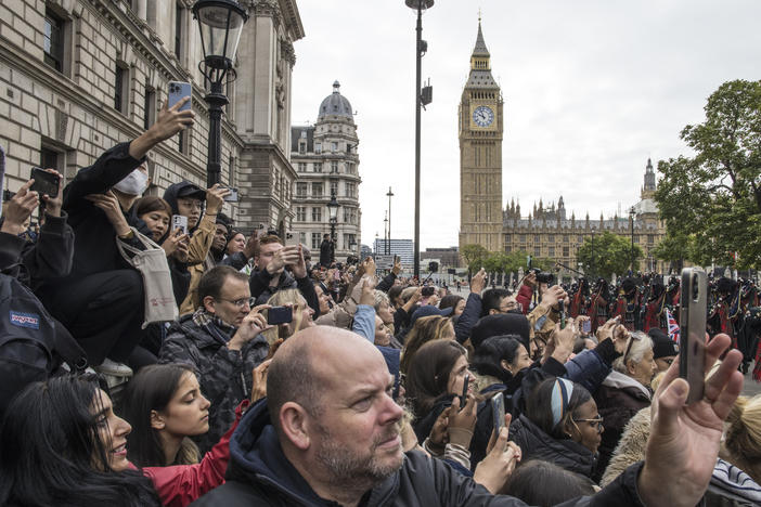 Mourners photograph the funeral procession as they gather to say goodbye to Queen Elizabeth II outside the Palace of Westminster and the houses of Parliament in London on Monday. The final leg of Monday's journey for Queen Elizabeth II, who served as the constitutional monarch of the United Kingdom for 70 years, follows a state funeral at Westminster Abbey and a procession through the city.