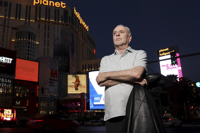 The late Jeff German, host of "Mobbed Up," poses with Planet Hollywood, formerly the Aladdin, in the background on the Strip in Las Vegas, on June 2, 2021.