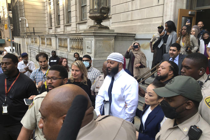 Adnan Syed (center) leaves a Baltimore courthouse on Monday after his conviction for a 1999 murder that was chronicled in the hit podcast <em>Serial</em> was vacated.