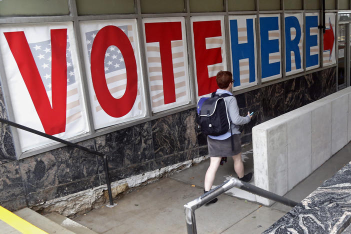 A voter passes large signs spelling out "Vote Here" in Minneapolis in September 2016. Voters in Minnesota can start casting their ballots for this year's midterm elections on Friday.