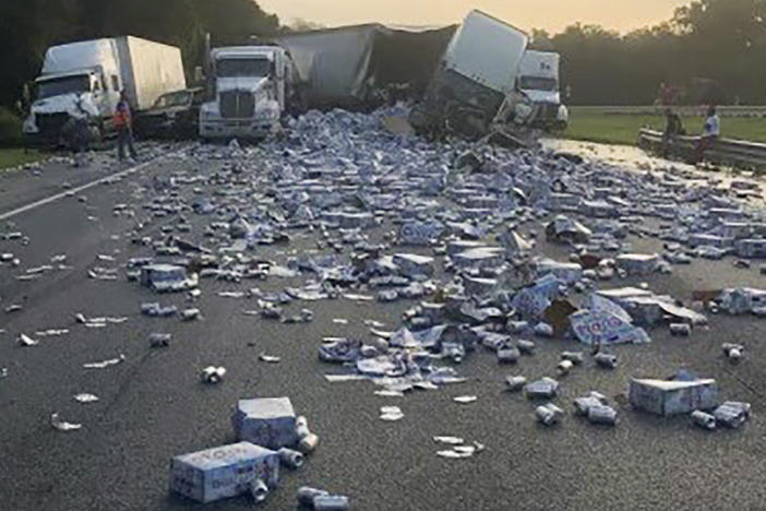 In this photo provided by Florida Highway Patrol, cases of Coors Light beer are strewn across a highway after two semitrailers collided on a Florida highway on Wednesday near Brooksville, Fla.