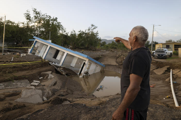A man on Wednesday points to a home that was collapsed by Hurricane Fiona at Villa Esperanza in Salinas, Puerto Rico.