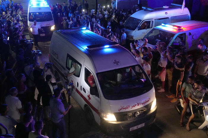 Lebanese Red Cross ambulances, carrying the bodies of people who died in a boat sinking, cross between Lebanon and Syria on Friday.