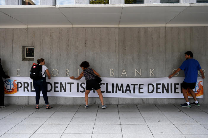 Activists unfurled a banner calling David Malpass a climate denier on the World Bank headquarters after he refused to say if he believed man-made emissions contributed to global warming.
