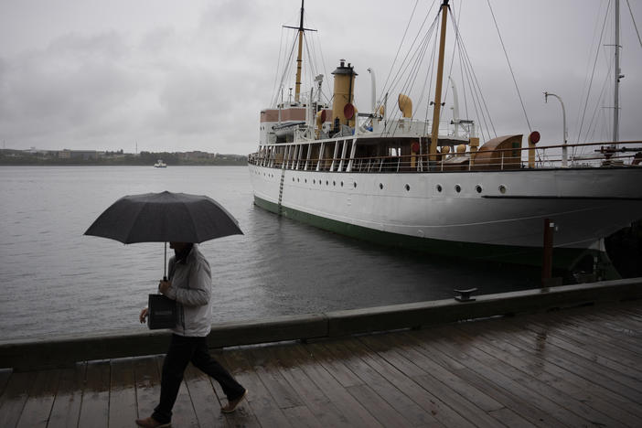 A pedestrian shields themselves with an umbrella on Friday while walking along the Halifax waterfront as rain falls ahead of Hurricane Fiona making landfall.