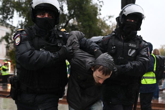 Police officers detain a man in Moscow on Saturday following calls to protest against the military draft announcement.