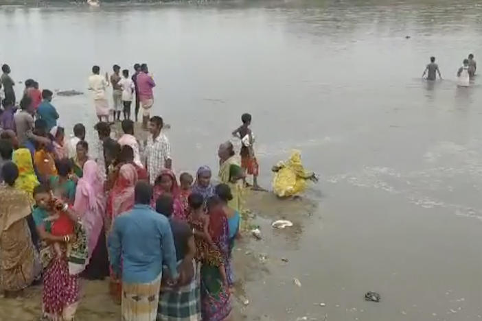 In this image made from a video, people conduct search operation in the River Karatoa, where an overcrowded boat overturned in Bangladesh on Sunday.