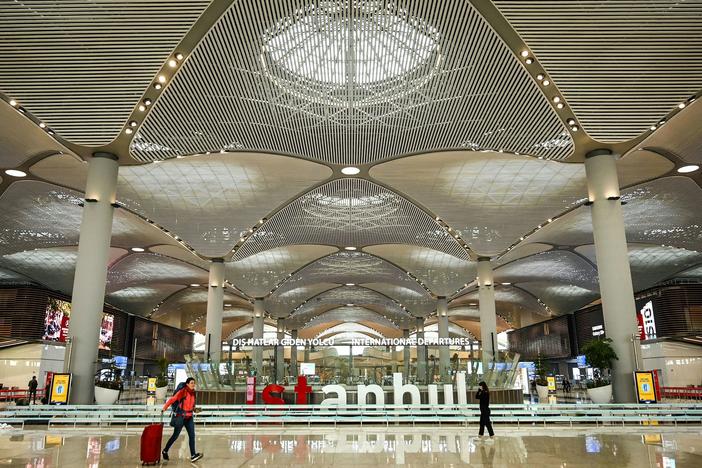 Passengers walk in the new hall of Istanbul Airport on the first day after moving from Ataturk International airport on April 6, 2019, in Istanbul. Many Russian men (not pictured) have been buying up tickets for Turkey since their government issued a draft to fight in Ukraine.