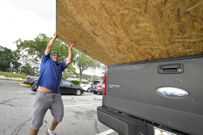Jesus Rodrigues loads wood into his vehicle Monday outside a Home Depot store in Orlando, Fla., in preparation for the arrival of Hurricane Ian.