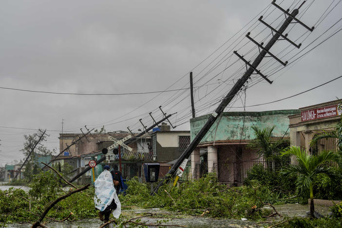 Fallen utility poles and branches line a street in Pinar del Rio, Cuba, on Tuesday after Hurricane Ian hit.