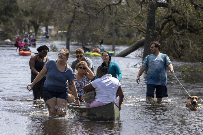 People leave the flooded community of Country Club Ridge in North Port Florida on September 29, 2022, after Hurricane Ian passed through the area a day earlier.