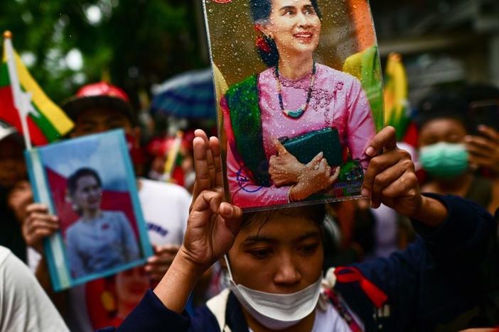 Protesters show the three finger salute and hold photos of detained Myanmar civilian leader Aung San Suu Kyi in July outside the Myanmar Embassy in Bangkok during a demonstration against the Myanmar military junta's execution of four prisoners.