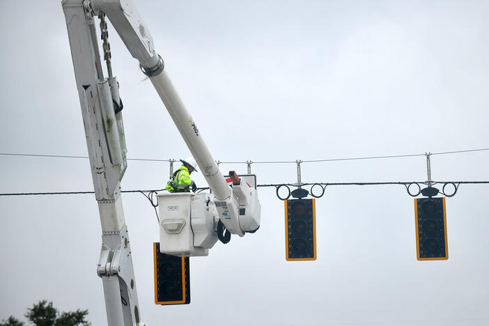 A worker repairs traffic lights during a power outage following Hurricane Ian on Thursday in Bartow, Fla.