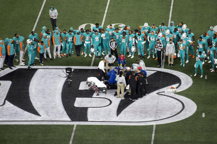 Teammates gather around Miami Dolphins quarterback Tua Tagovailoa (1) after an injury during the first half of an NFL football game against the Cincinnati Bengals, Thursday, Sept. 29, 2022, in Cincinnati.