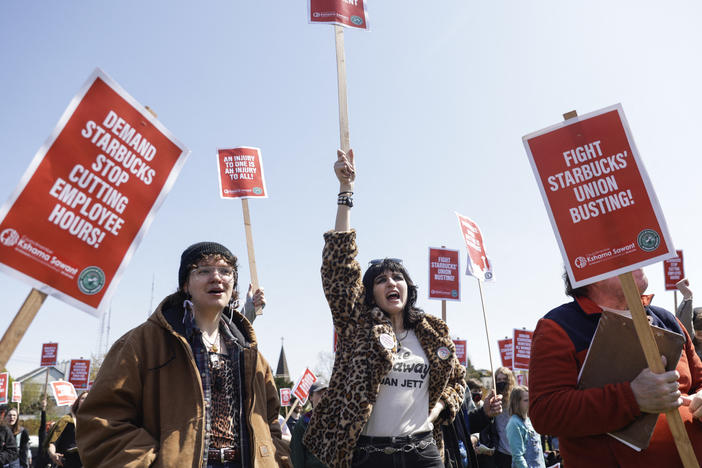 Marchers raise picket signs during a "Fight Starbucks' Union Busting" rally held in Seattle in April.