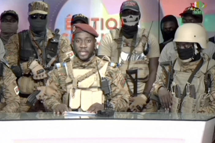 In this image from video broadcast by RTB state television, coup spokesman Capt. Kiswendsida Farouk Azaria Sorgho reads a statement in a studio in Ougadougou, Burkina Faso, on Friday evening.