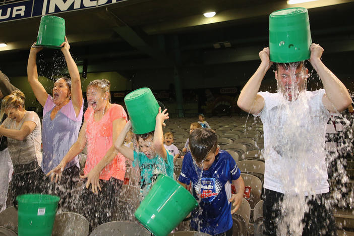 Participants tip buckets of ice water over their heads as they take part in the World Record Ice Bucket Challenge at Etihad Stadium on Aug. 22, 2014, in Melbourne, Australia.